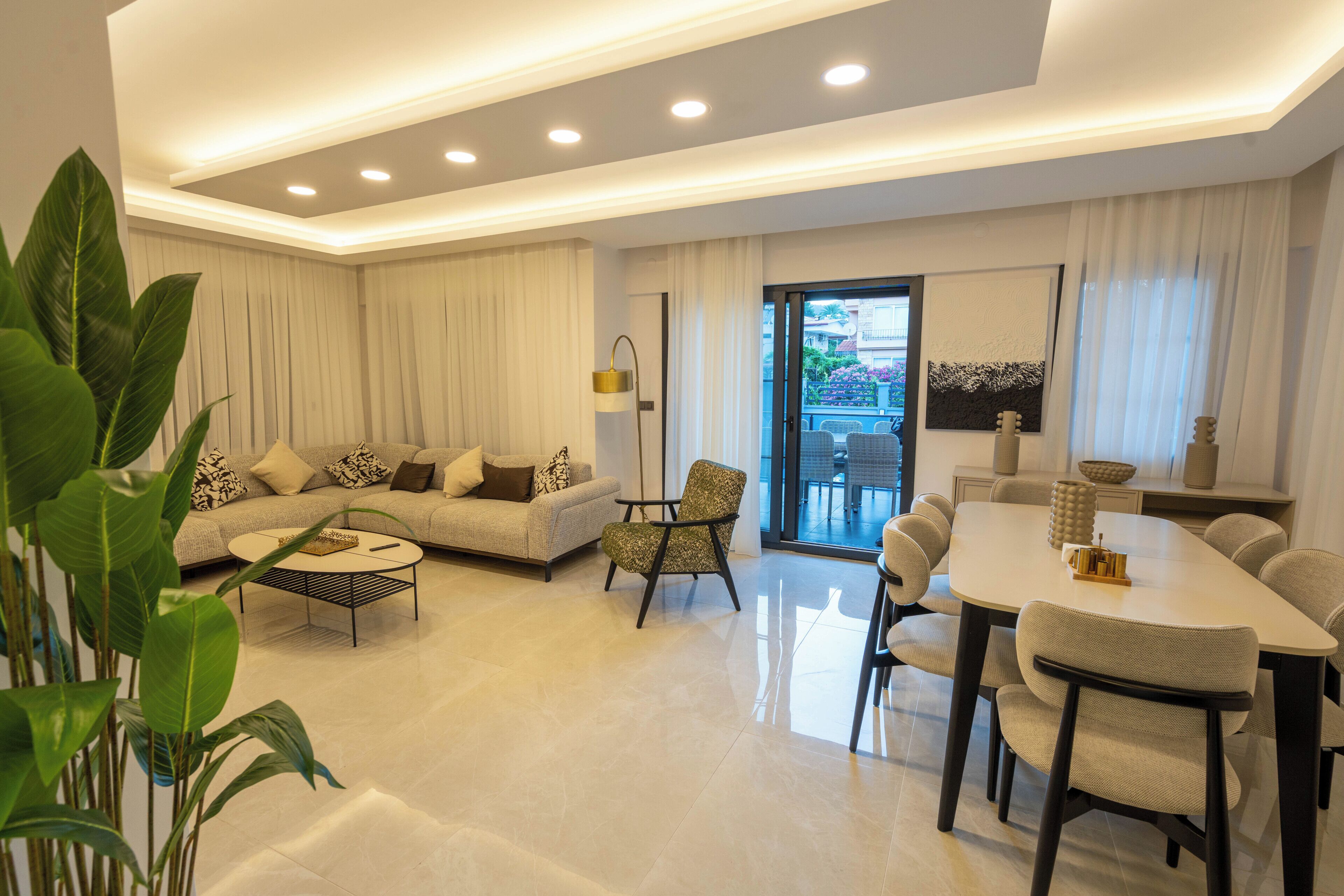 A modern living room with a sofa, coffee table, dining table, and chairs.