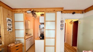Una cocina compacta con armarios de madera, una cafetera y un microondas.