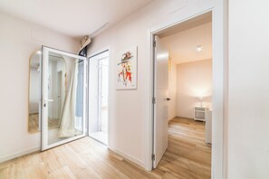 Ein Flur mit einer Spiegelstür, einem Gemälde und einer Lampe.