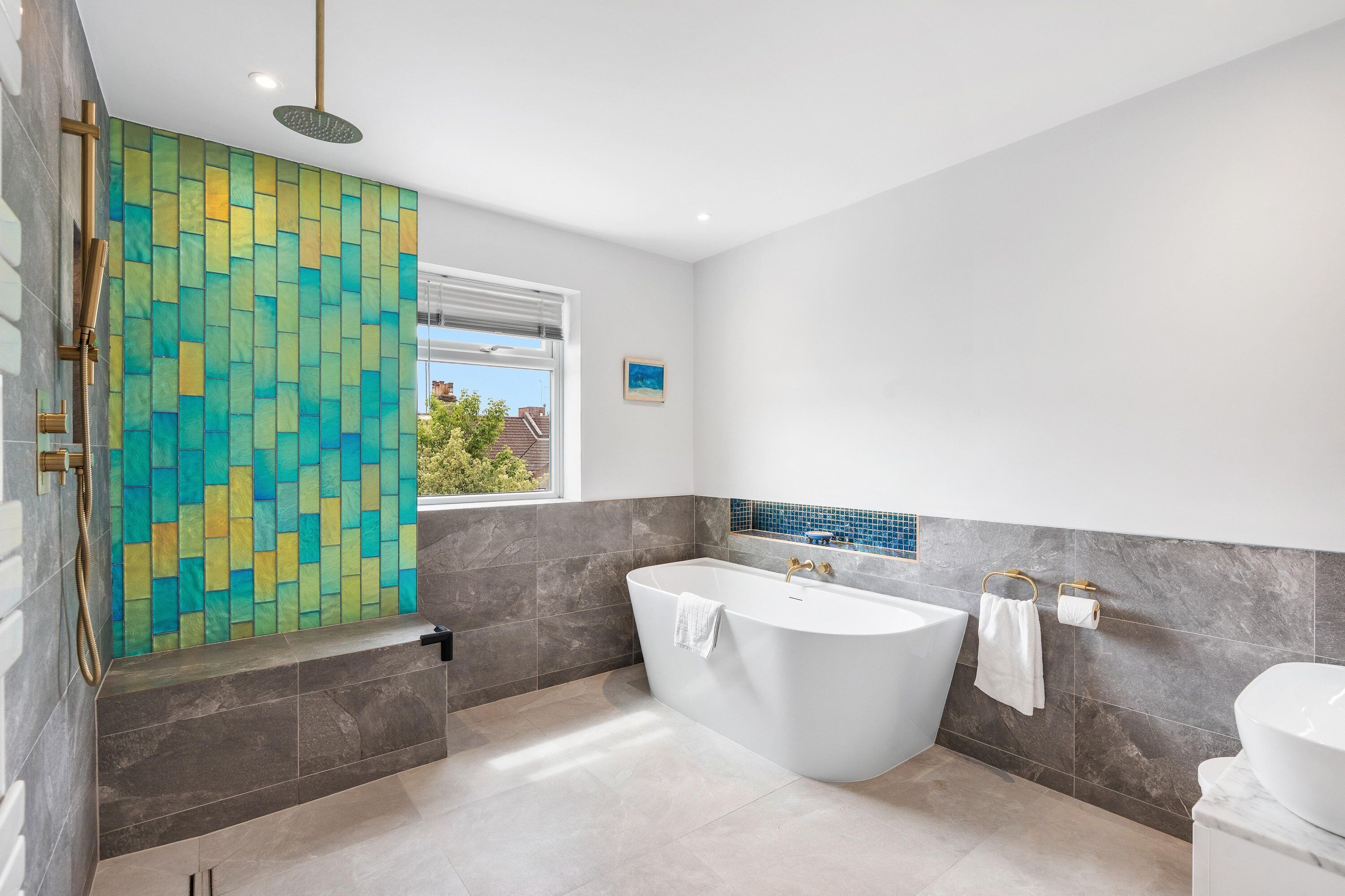 A modern bathroom with a freestanding bathtub, a shower, and a toilet.
