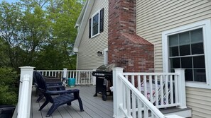 A covered deck with outdoor furniture, a grill, and a white railing. - Beautiful Townhouse close to both Short Sands and. (York)