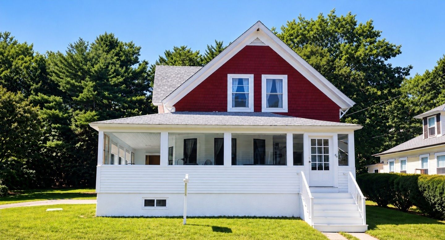A single-story house with a gabled roof, a front porch with steps, and a small front yard.