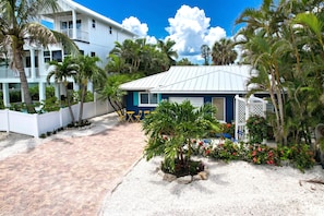 A resort with a pool, palm trees, and a building with a blue roof.