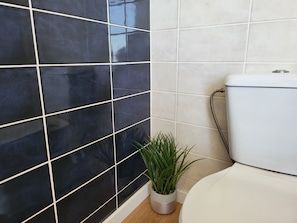 A bathroom with black and white tiles, a toilet, and a potted plant. - Barco Casa Aveiro (Aveiro)
