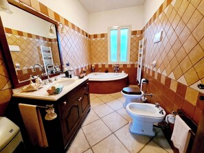Ein Badezimmer mit Waschbecken, Waschtisch, Badewanne, Toilette und Bidet.