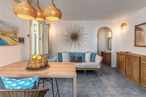 A dining area with a wooden table, wicker chairs, and a wicker basket with fruit. - Lapuritate Via Cariddi - Bilo terrazza sul mare (Gallipoli)