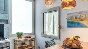 Eine Küche mit Fenster, einem Esstisch und einem Korbkörbchen mit Zitronen.