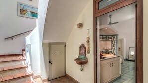 A staircase leading to a bathroom with a sink and tiled floor. - Lapuritate Via Cariddi - Monolocale piano terra (Gallipoli)