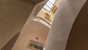 Un elemento arquitectónico curvo, una pintura en la pared y una ventana con vistas.