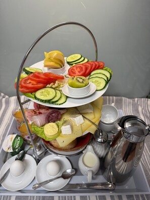 Exposição de alimentos em diferentes níveis, com diversos queijos, frutas e legumes.