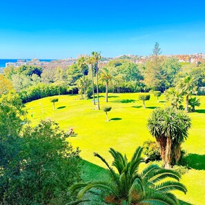 A park with manicured lawns, palm trees, and a distant cityscape. - Charming apartment in Minerva Building, just a short walk from the beach in Arroyo de la Miel (Arroyo de la Miel)