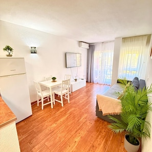 A compact living space with a dining area, a bed, a TV, and a small kitchenette. - Charming apartment in Minerva Building, just a short walk from the beach in Arroyo de la Miel (Arroyo de la Miel)