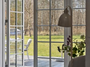 Ein Zimmer mit einem großen Fenster, einem weißen Stuhl und einem Holzboden.