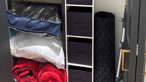 Makuuhuoneessa on kerrossänky, vaatekaappi, jossa on useita säilytystiloja, ja pieni pöytä.