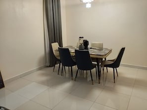 A dining area with a table, chairs, and a blender. - Vision Luxury Apartment (Lekki)