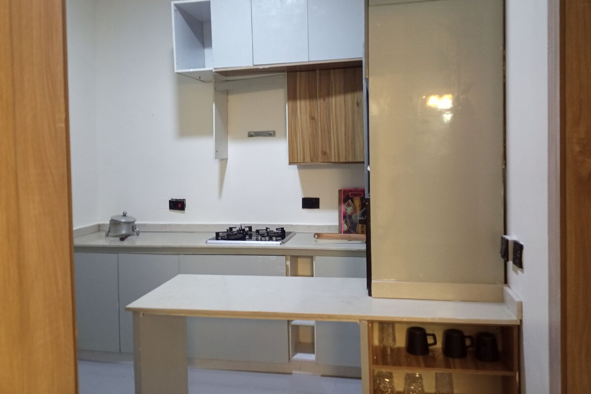 Una cocina moderna con armarios blancos, estufa a gas y encimera.