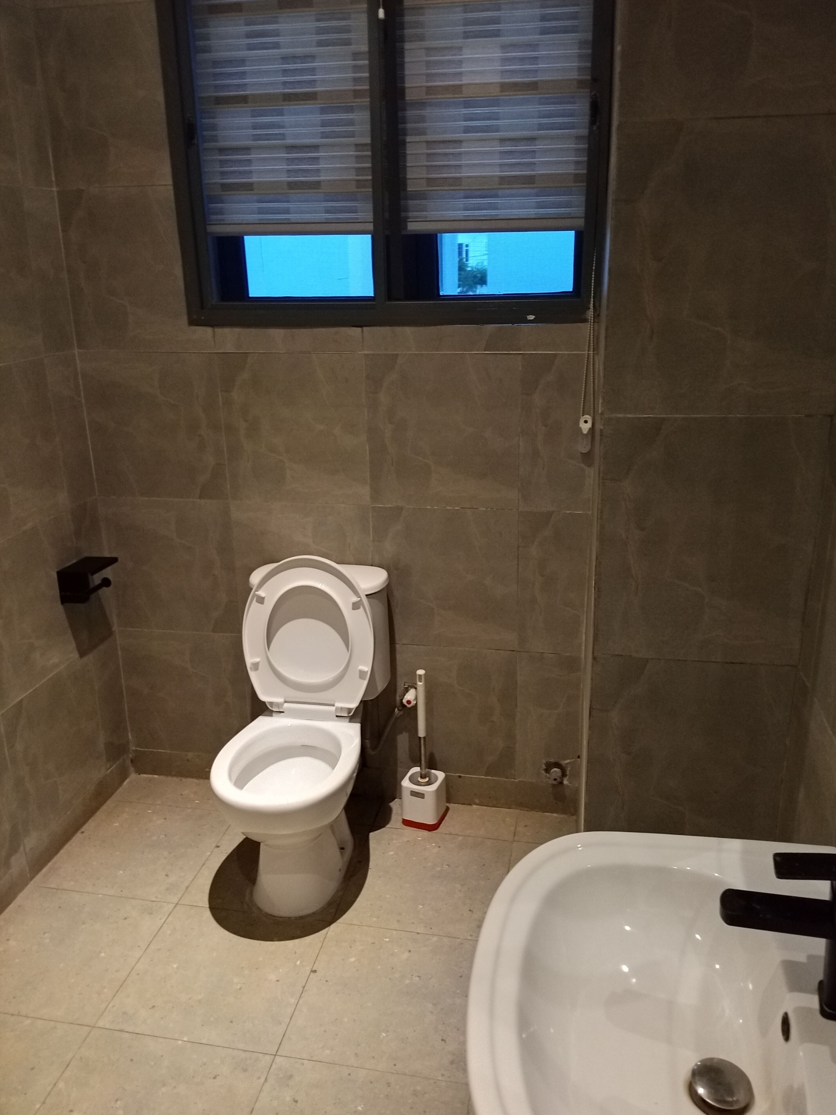 Un baño con inodoro, bidé y lavamanos.