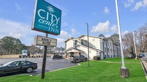A CITY CENTER INN sign, a building with a flat roof, and a parking lot. - City Center Inn (Newport News)