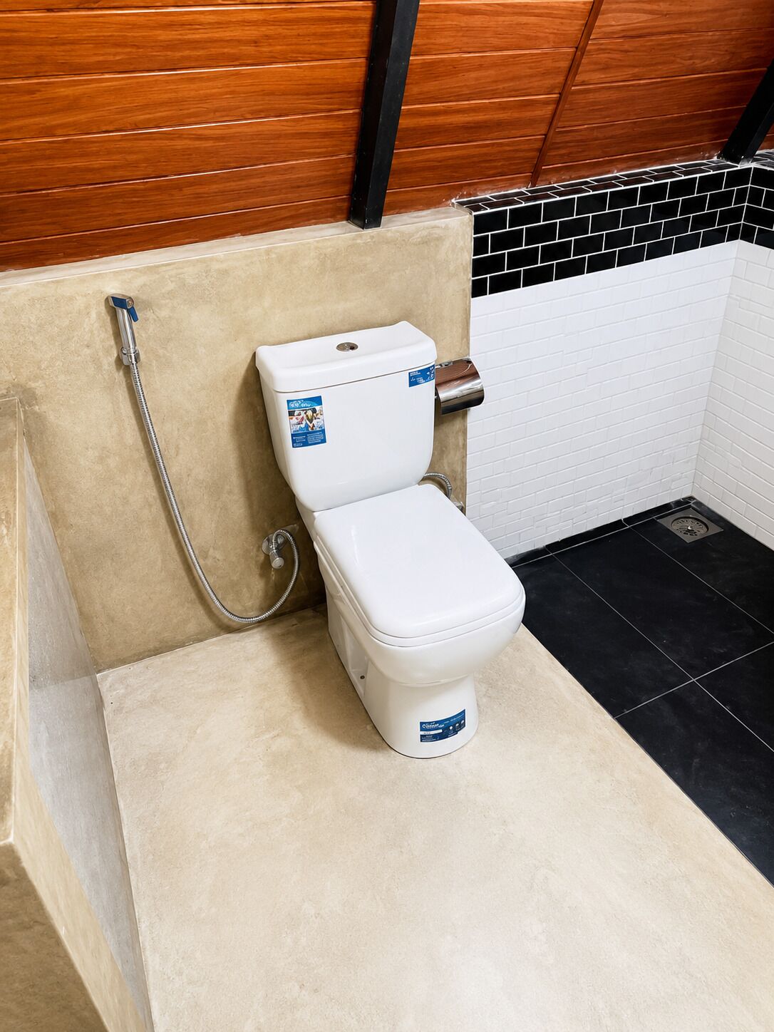 A bathroom with a white toilet, a shower, and a tiled floor.