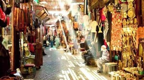 Una calle estrecha bordeada de tiendas que exhiben diversos productos.