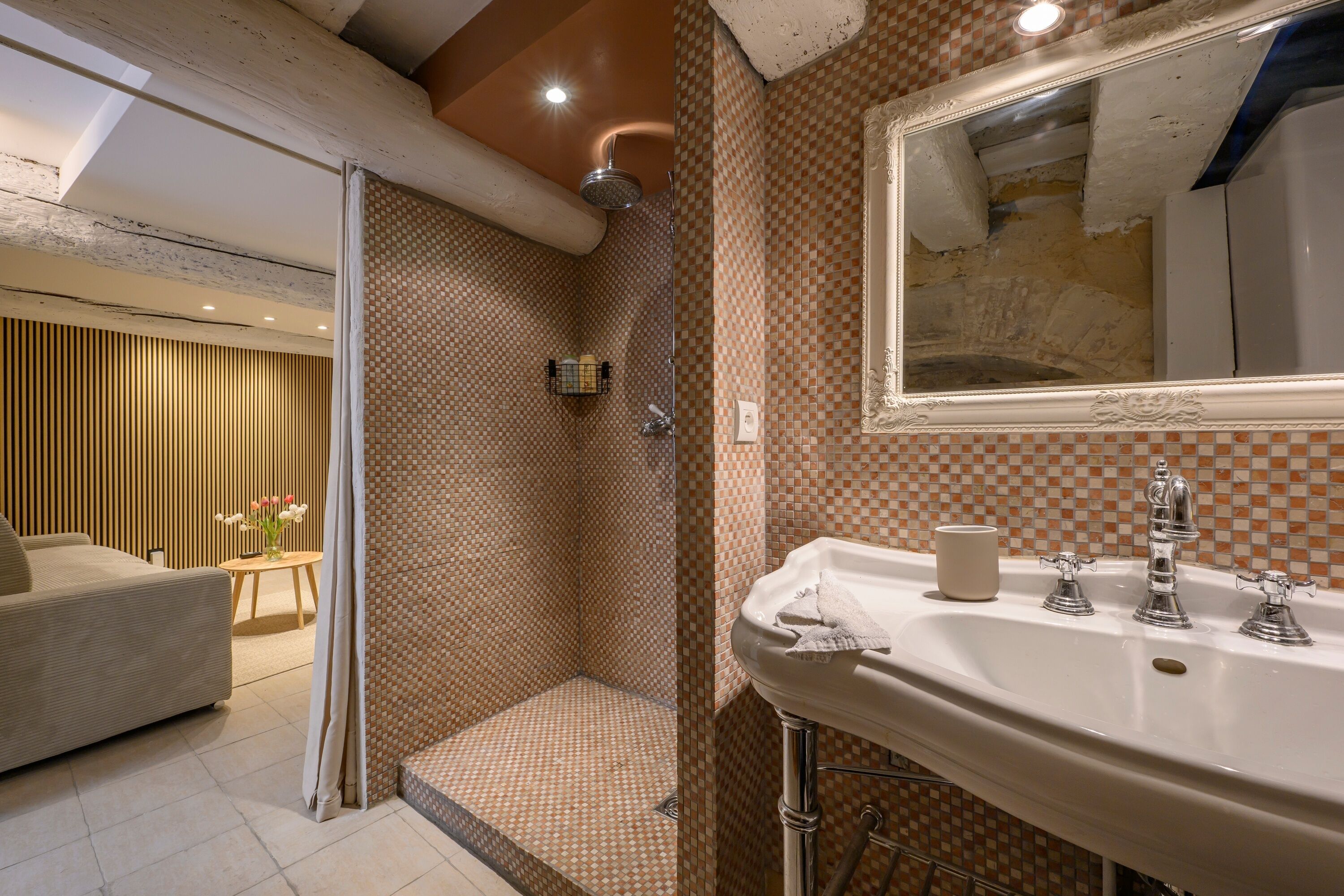 Une salle de bain avec une douche, un lavabo avec un miroir et des toilettes.