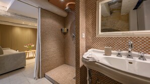 Ein Badezimmer mit Dusche, Waschbecken inklusive Spiegel und Toilette.