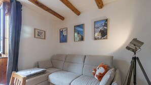 Una habitación con un sofá, una lámpara y cuadros en la pared.
