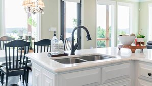 A kitchen with a large island, a double sink, and a chandelier. - Enjoy stunning Pickwick Lake views and water access from Aqua Vista Pickwick! (Hardin County)