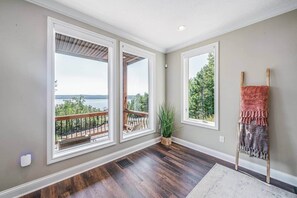 Ein Zimmer mit großen Fenstern, Holzboden und Blick auf einen See.
