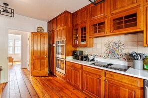 Eine Küche mit Holzausstattung, einem Edelstahlkühlschrank und einer gefliesten Spritzwand.