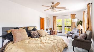 Une chambre à coucher avec un lit, une chaise, une lampe et un ventilateur de plafond.