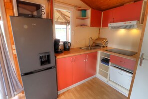 A compact kitchen with a refrigerator, sink, and microwave.