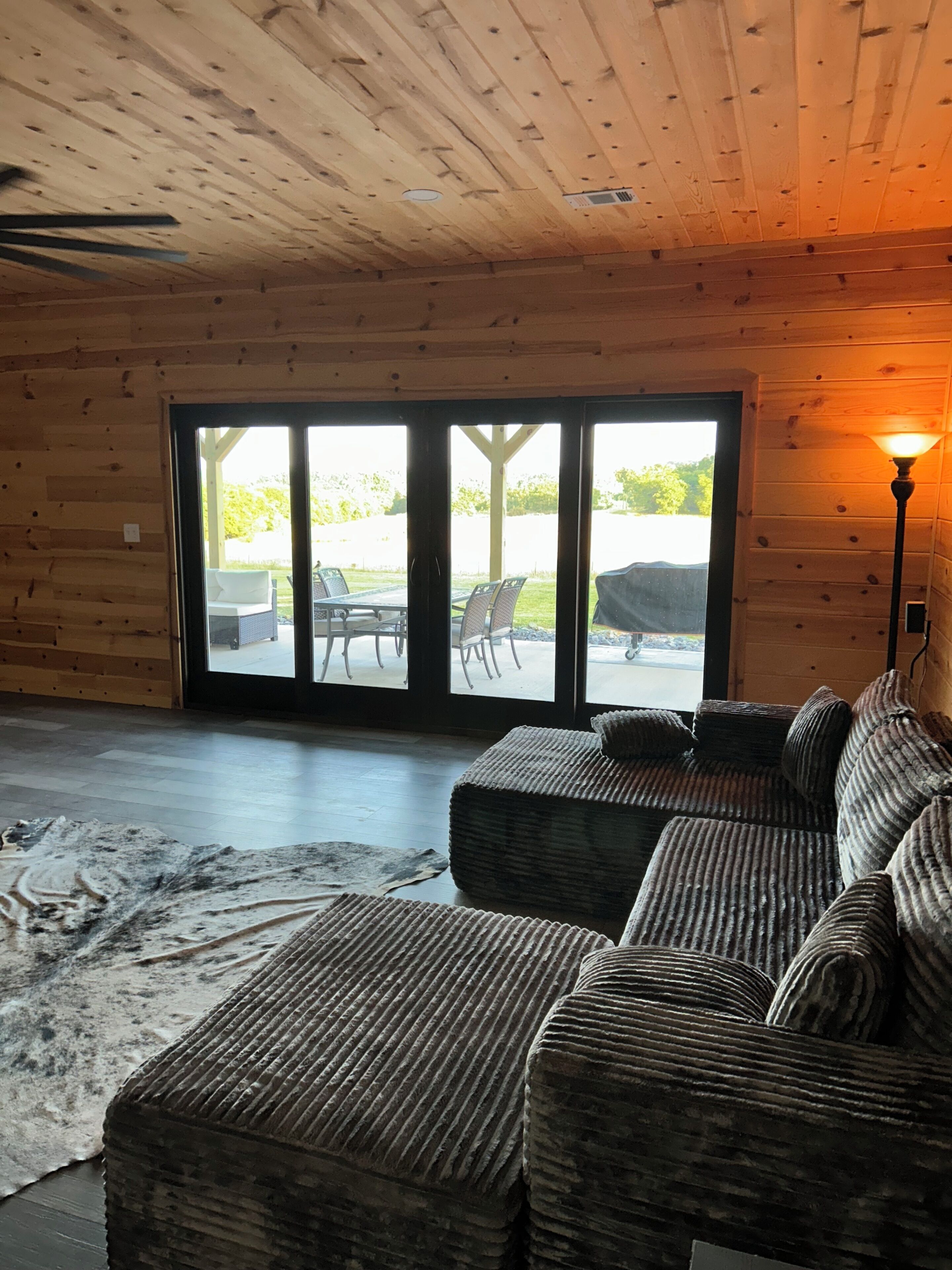 L'intérieur d'une cabane en rondins, avec un canapé, un tapis et une lampe.