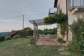 A patio with a pergola, outdoor furniture, and a view of a hillside. - Amazing view 2-bedroom country house (Dogliani)