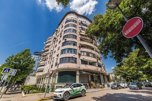 Un edificio de varios pisos con fachada curva, señal de paso para peatones y señal de prohibido el acceso.