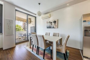 Un comedor moderno con una mesa, sillas, una lámpara en el techo y un equipo de aire acondicionado.