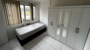 A room with a bed, a wardrobe, and a window with blinds. - Incredible Suite Dreams and Beach (Rio de Janeiro)
