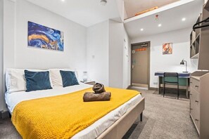 A hotel room with a bed, a desk, and a chair. - Stylish City-Centre Stay in Leicester | Market St (Leicester)