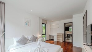 Een moderne hotelkamer met een groot bed, een bureau en een inloopkast.