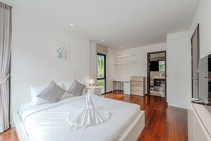 Ein modernes Hotelzimmer mit einem großen Bett, einem Schreibtisch und einem begehbaren Kleiderschrank.