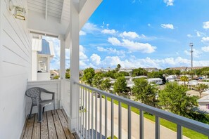 Ein Balkon mit Blick auf ein Wohngebiet, einem Stuhl und einem Geländer.