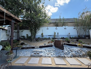 A garden with a Buddha statue, a pergola, and a white fence. - Cozy Foothill retreat in serene Tujunga (Tujunga)