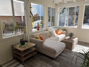 A cozy living room with a sofa, a coffee table, and a window overlooking a garden. - Cozy Foothill retreat in serene Tujunga (Tujunga)