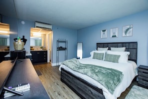 Ein Schlafzimmer mit einem Bett, Nachttischen, einem Schreibtisch und einem Sessel.