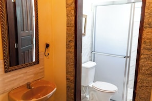 Un baño con lavamanos, espejo e inodoro.