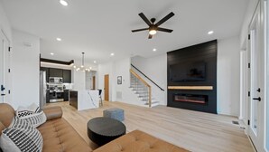 Ein modernes Wohnzimmer mit einer Couch, einem Hocker und einem Kamin.