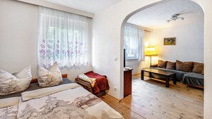 Una habitación con cama, sofá, una mesita y una lámpara.