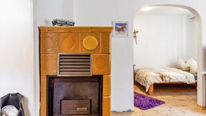 Una habitación con chimenea, una cama y una puerta que da a otra estancia.