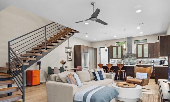 Un espacio habitable moderno con escalera, cocina y zona de estar.