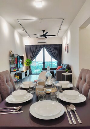 A dining area with a table set for four, a ceiling fan, and a view of the outdoors.